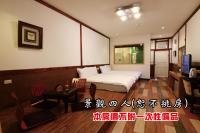 a bedroom with a bed and a table and a desk at Tingtau Villa in Lugu Lake
