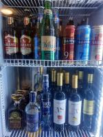 Зона отдых APACHI в горах ЧИМГАН في Chimgan: ثلاجة مليئة بالكثير من زجاجات الكحول