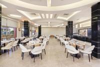 a dining room with tables and white chairs at Pickalbatros Aqua Blu Sharm El Sheikh in Sharm El Sheikh