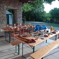 een groep houten tafels met kommen en glazen erop bij CAMPING LE BEL AIR tente insolite Sibley's 4 personnes-LE ROMARIN in Limogne-en-Quercy