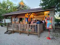 een groep mensen die buiten een restaurant staan bij CAMPING LE BEL AIR tente insolite Sibley's 4 personnes-LE ROMARIN in Limogne-en-Quercy