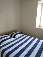 a blue and white striped bed in a bedroom at La maison bleue in Grane