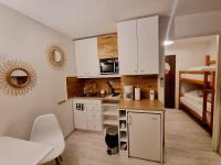a small kitchen with white cabinets and a bunk bed at 100 m de la plage - Les Cigales de Mer - Studio Cabine - Parking in Le Grau-du-Roi