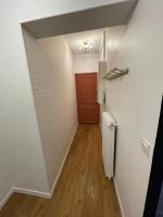 a hallway with a red door and a wooden floor at Smart Inn Melun Centre- Appartement 2 chambres in Melun