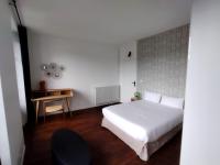 a bedroom with a white bed and a table at Smart Inn Melun Centre- Appartement 2 chambres in Melun