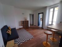 a living room with a couch and a table and stool at Smart Inn Melun Centre- Appartement 2 chambres in Melun