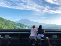 dos personas sentadas en sillas mirando a una montaña en Mizno Hotel, en Fujikawaguchiko