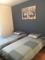 a bedroom with two beds and a picture of deer at centre Pierrefonds superbe appartement + parking in Pierrefonds