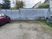 a car parked in a driveway next to a fence at centre Pierrefonds superbe appartement + parking in Pierrefonds