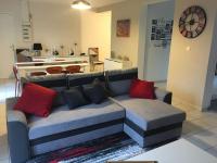 a couch with red pillows in a living room at centre Pierrefonds superbe appartement + parking in Pierrefonds