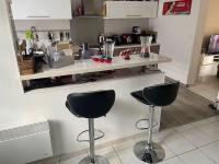 a kitchen with two bar stools in front of a counter at centre Pierrefonds superbe appartement + parking in Pierrefonds