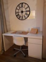 a desk with a clock on the wall and a chair at Rooms 6 persons Kaysersberg in Kaysersberg