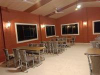 una sala da pranzo con tavoli, sedie e pareti rosse di Sk Resort ad Alibaug