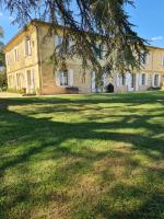 a large house with a large yard with a tree at Jardin Meurin in Tabanac