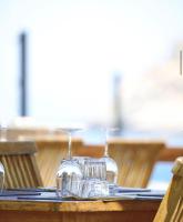 a table with two wine glasses on top of it at Hôtel de la jetée in Centuri