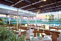 Un restaurante con mesas y sillas y vista al agua. en JW Marriott Desert Springs Resort & Spa, en Palm Desert