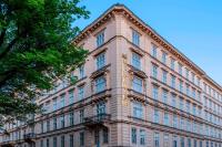 a large brick building with windows and a tree at Le Méridien Vienna in Vienna
