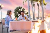 a man and woman sitting at a table in front of a fire at Marriott Marquis San Diego Marina in San Diego