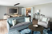 a living room with a blue couch and a room with a bed at Orlando World Center Marriott in Orlando