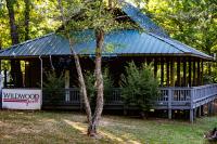 una grande casa in legno con un albero di fronte di Wildwood Resort a Zwolle