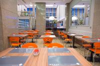 un comedor con mesas, sillas y sillas de color naranja en Hotel Continental Business - 200 metros do Complexo Hospitalar Santa Casa, en Porto Alegre