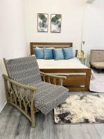 Un dormitorio con una cama con almohadas azules y una silla en Roemah lily studio, en Tanah Rata