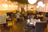 a dining room with tables and chairs and lights at Hotel Polo Towers Shillong in Shillong