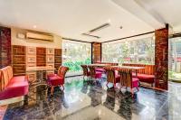 Un restaurante con sillas y mesas rojas y ventanas. en Summit Calangute Resort & Spa, en Calangute