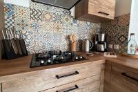 a kitchen with a stove and a tile wall at La Reinette du Verger 9 d&#39;Arry 1 in Arry