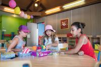 three girls sitting at a table playing with toys at SOWELL RESIDENCES Les Sablons in Le Grau-du-Roi
