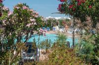 a swimming pool with chairs and trees and flowers at SOWELL RESIDENCES Les Sablons in Le Grau-du-Roi