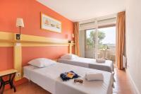 a hotel room with two beds and a balcony at SOWELL RESIDENCES Les Sablons in Le Grau-du-Roi