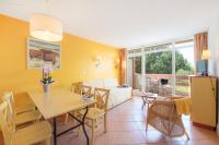 a living room with a table and chairs and a couch at SOWELL RESIDENCES Les Sablons in Le Grau-du-Roi