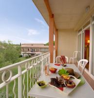 a balcony with a table with food on it at SOWELL RESIDENCES Les Sablons in Le Grau-du-Roi