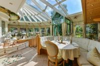 un salón acristalado con mesa, sillas y techo de cristal en Apart Lech, en Holzgau