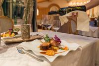 una persona está vertiendo vino en un plato de comida en Apart Lech, en Holzgau