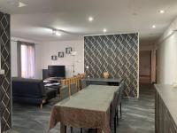 a living room with a table and a couch at Appartement all in grey in Agen