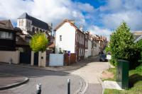 a street in a town with houses and a car at Appt cosy coeur historique+park, 5mn gare Vernon in Vernon