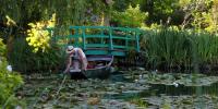 a person in a boat in a pond with a bridge at Appt cosy coeur historique+park, 5mn gare Vernon in Vernon