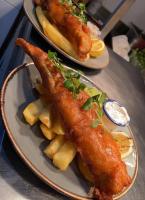 zwei Teller mit Essen mit Fisch und Chips auf einem Tisch in der Unterkunft Palmer's Ale House in Long Sutton