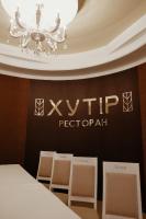 a chandelier hangs above a table and two chairs at Готель Хутір in Malyye Khutora