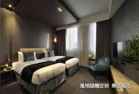 a hotel room with two beds and a television at Boda Hotel in Taichung
