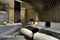 a hotel room with two beds and a television at Boda Hotel in Taichung