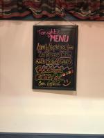 a chalkboard with a menu on a wall at Hôtel des Alpes - Skiers & Bikers Lodge in La Grave