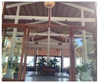 a lobby with a large wooden ceiling and windows at Bamboo Cottages in Phu Quoc