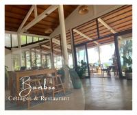 a restaurant with a table and chairs and windows at Bamboo Cottages in Phu Quoc