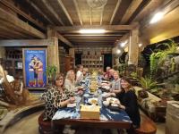 プレーにあるBaanthep Antique Homestayの食卓に座る人々