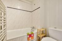 a white bathroom with a tub and a toilet at Studio cosy idéal pour 2 personnes situé à Lyon in Lyon