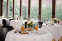 a dining room with tables with white table cloths and drinks at Hotel Pausania in Venice