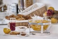 a table with a bowl of fruit and a basket of bread at Hotel Pausania in Venice